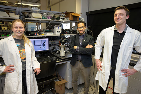 Three Wayne State researchers smiling in their lab