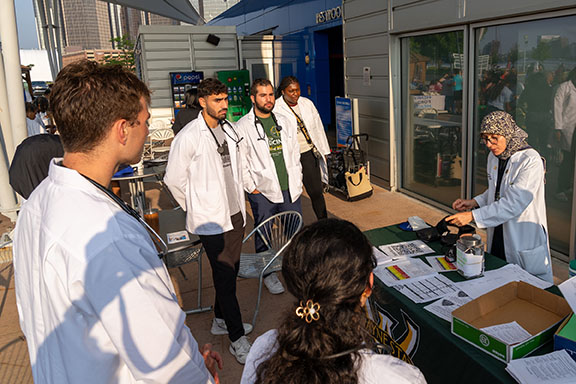 School of Medicine students outside at a table watching a demonstration